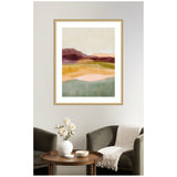 Framed abstract landscape artwork with layered horizontal bands in burgundy, peach, mustard, olive, and teal tones hung above a brown round table and two olive armchairs.