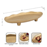 Gold-finished, sand-cast textured metal oval tray with a deckled edge and short cylindrical feet, measuring 14 by 7.5 by 2 inches.