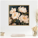 Square framed canvas featuring four large creamy white peony blooms with green leaves against a dark background, hanging on a white wall above a neutral-toned tabletop display.