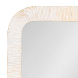 Close-up of a rectangular mirror corner with a rounded edge and a textured whitewashed wooden frame featuring vertical grooves.