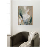 Abstract canvas wall art with soft brushstrokes in beige, green, and gray tones, framed in a simple wood frame, hanging above a dark olive-green armchair with a knitted cream throw.