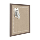 Rectangular beige fabric pinboard with a white scalloped border inside a dark brown wood frame, displaying two black-and-white pinned photos on the upper left side.