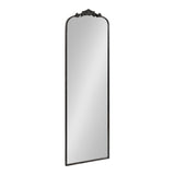 Tall rectangular mirror with an arched top and ornate dark carved floral decoration centered above the arch, framed in a thin matching dark border.