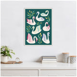 Framed canvas artwork featuring six stylized swans in white with colorful feather accents and surrounding green leaves on a teal background, hanging above a white dresser.