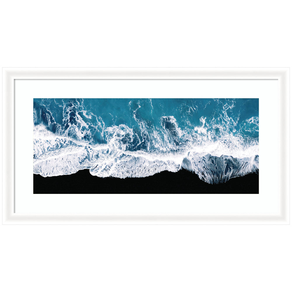 Framed minimalist art print showing aerial view of ocean waves crashing on a black beach in Iceland by Michael Schauer