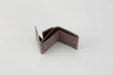 Folded wallet with a purple interior and plaid-patterned exterior, partially open to show inner compartments and gold snap buttons.