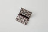 Open rectangular business card case with a brown and white geometric zigzag pattern, showing an empty interior on a white surface.