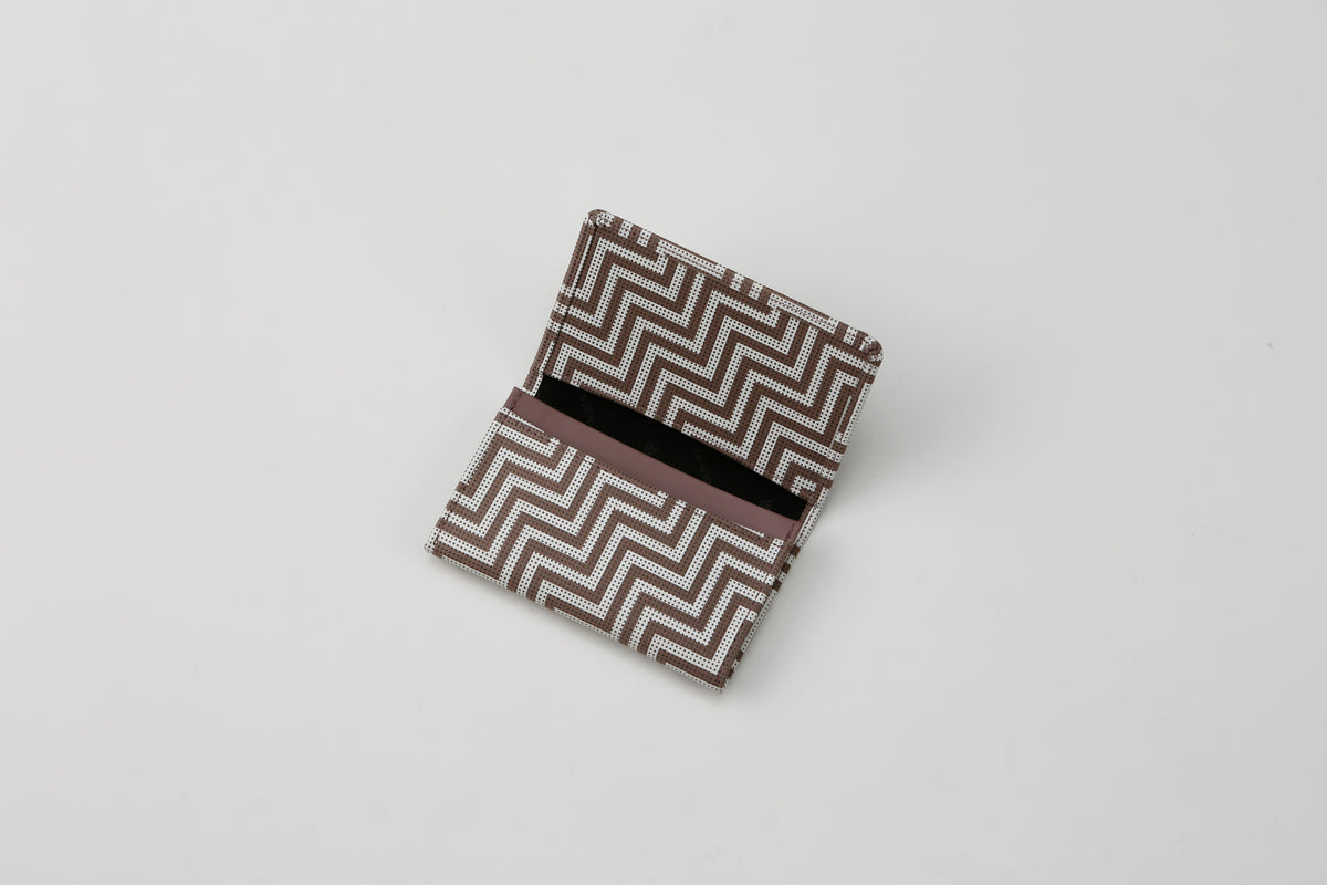 Open rectangular business card case with a brown and white geometric zigzag pattern, showing an empty interior on a white surface.