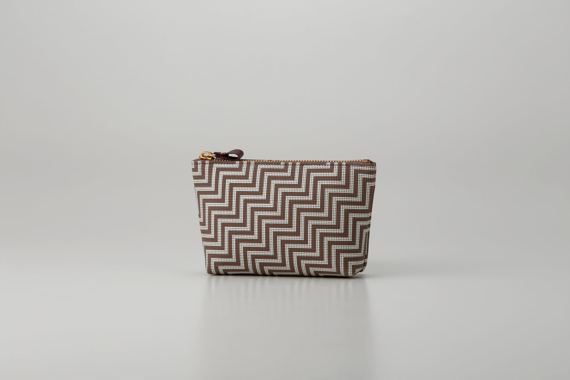 Rounded trapezoid brown deer skin pouch with white hand-drawn pattern and gray lacquered dots