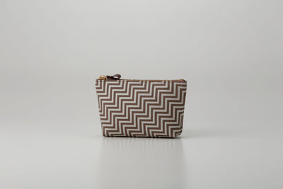 Rounded trapezoid brown deer skin pouch with white hand-drawn pattern and gray lacquered dots