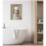 Framed canvas print of a fluffy brown bunny sitting on a toilet with a roll of toilet paper balanced on its head, hanging on a white bathroom wall above a modern bathtub.