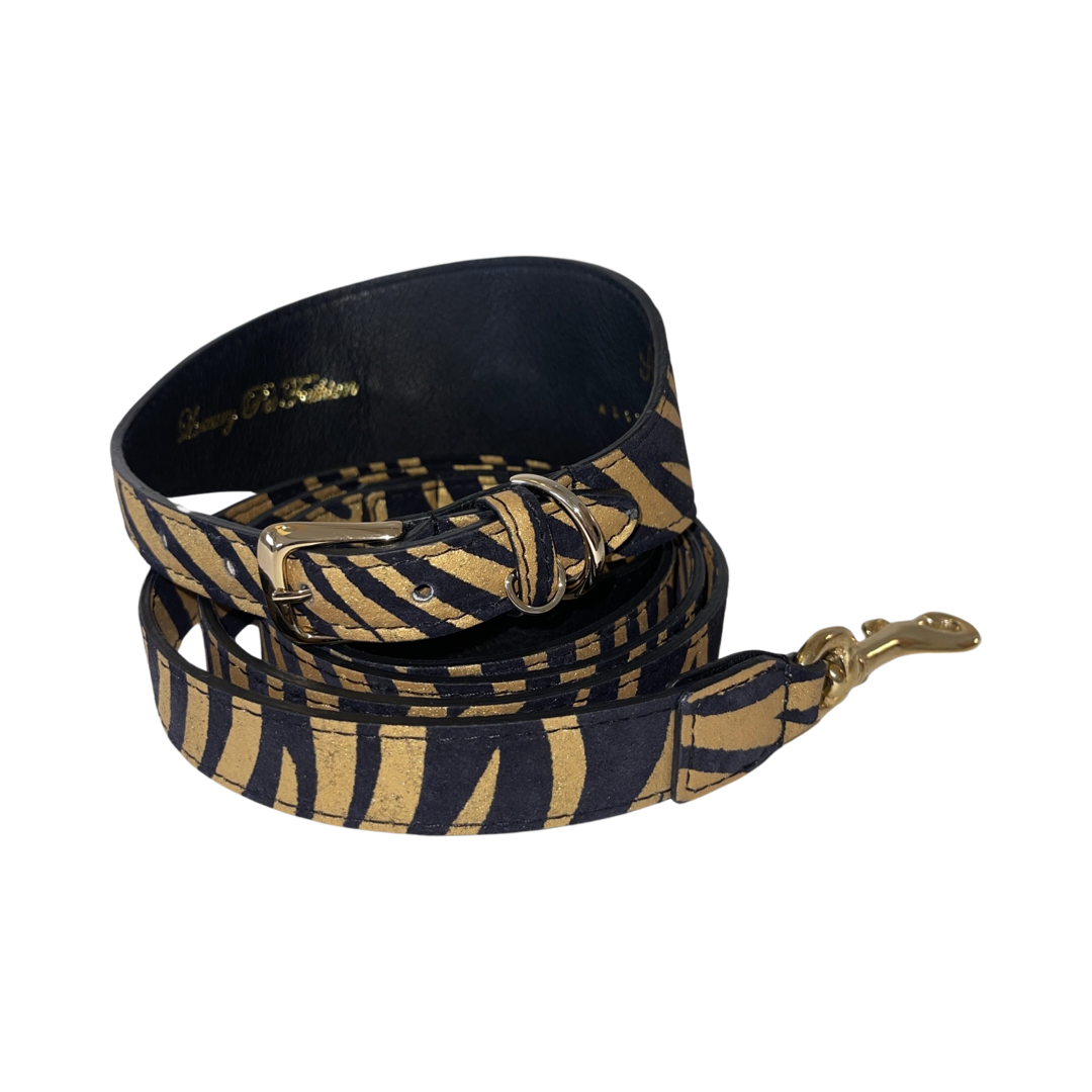 Black and gold leather collar and matching leash set with zebra stripe pattern and gold hardware, shown coiled against a plain background.