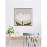 Minimalist framed canvas print of a white tulip with green leaves against a muted gray background, hanging above a light wood desk with a plant and decorative metal wire sphere.
