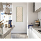 Minimalist kitchen corner with grey stone countertops, white cabinets, a beige lattice-patterned print framed on the wall, and a blue pitcher with two beige mugs on the counter.
