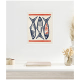 Framed canvas print of three stylized blue fish with patterned details and two horizontal red lines, hung on a white wall above a shelf with neutral-toned decor.