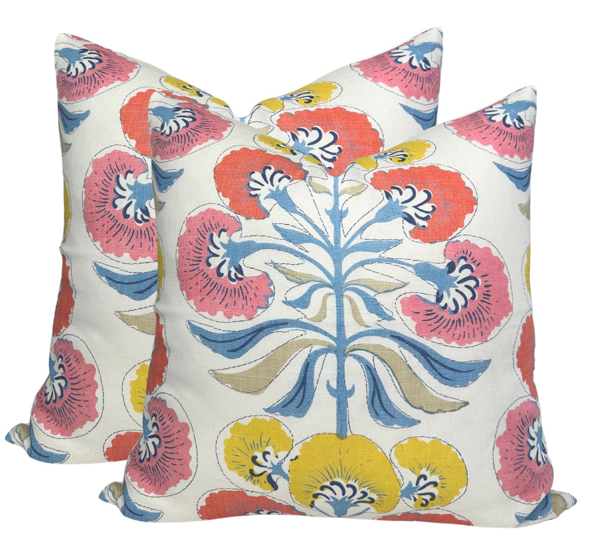 Two square pillows with white background featuring a coral, yellow, and blue floral tree motif with stylized petals and curved leaves.