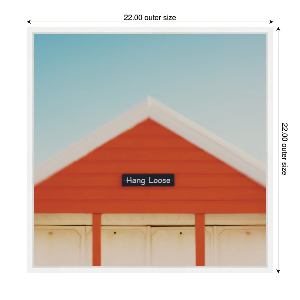 Gable of an orange wooden building with white trim under a clear blue sky, featuring a small black sign that reads 'Hang Loose'.