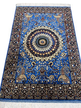Sky blue hand-knotted Afghan wool rug with a central medallion, surrounded by detailed floral patterns and a dark intricate border, finished with white fringe edges.