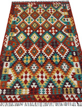Rectangular Afghani Maimana Kilim wool rug featuring geometric diamond and zigzag patterns in red, teal, yellow, white, and brown with fringed edges.