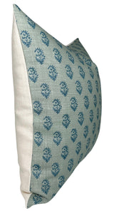 Side view of a rectangular pillow with a textured blue fabric front featuring small dark blue floral motifs and plain off-white fabric on the side panel.