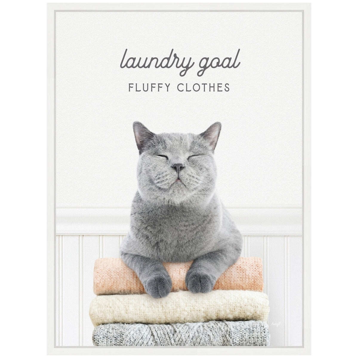 Gray short-haired cat resting with closed eyes and paws on a stack of three folded knit sweaters in beige, cream, and gray, against a white background with text 'laundry goal FLUFFY CLOTHES'.