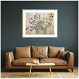 Framed abstract painting of an olive tree branch with muted green and brown leaves on a beige background, hung above a brown leather sofa against a dark teal wall.