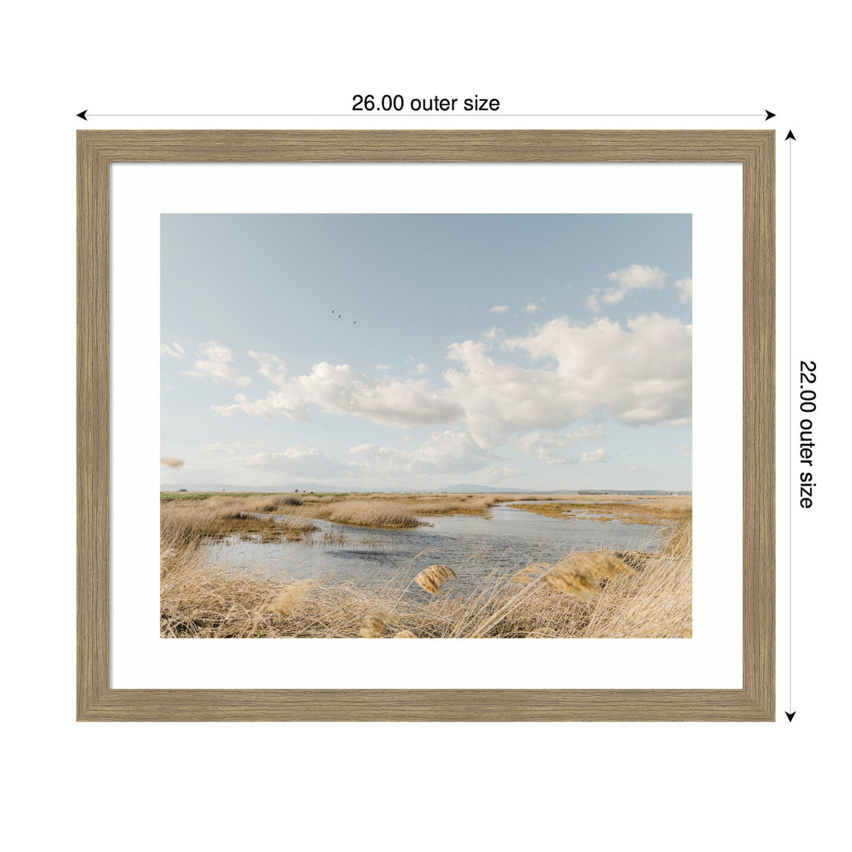 Framed photograph of a marshland with golden grasses and calm water under a partly cloudy blue sky, captured by Crystal Lynn Collins.