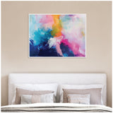 Abstract canvas artwork featuring vibrant blends of blue, pink, orange, and white hues in dynamic brushstrokes above a bed with neutral-toned pillows and beige wall.