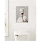 Framed canvas art of a white swan with a black beak holding a roll of toilet paper balanced on its head, hanging above a white toilet tank in a bathroom.