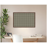 Rectangular sage green fabric pinboard with white plaid lines framed in dark wood, hanging above a white desk beside a tall green leafy plant.