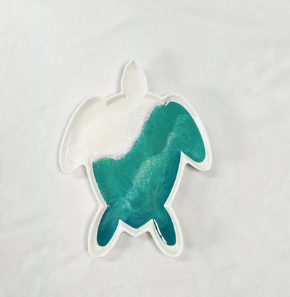 Teal and white turtle-shaped resin ceramic tray on a light gray background