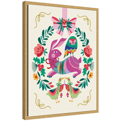 Framed canvas art of woodland animals Christmas wreath showing rabbit with bow, multicolored bird on its back, surrounded by leaves and flowers with birds holding candles