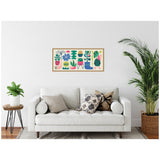 Framed canvas with retro-style bright floral and succulent illustrations in green, pink, blue, and yellow above a white couch with patterned pillows, flanked by green plants.
