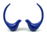 Pair of glossy blue bird figurines with long upward-curving tails, facing each other on a white background.