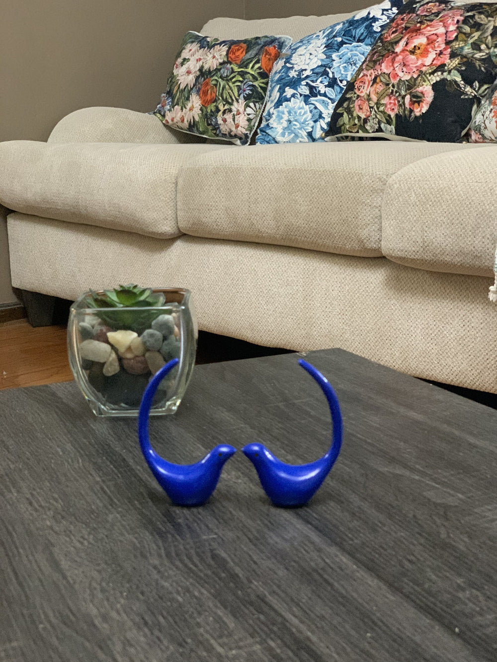 Two blue bird figurines sitting side by side on a flat surface