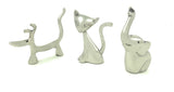 Silver-toned metal ring holders shaped like a dog with a raised tail, a sitting cat with a curved tail, and an elephant with a raised trunk, all minimalist and smooth in design.