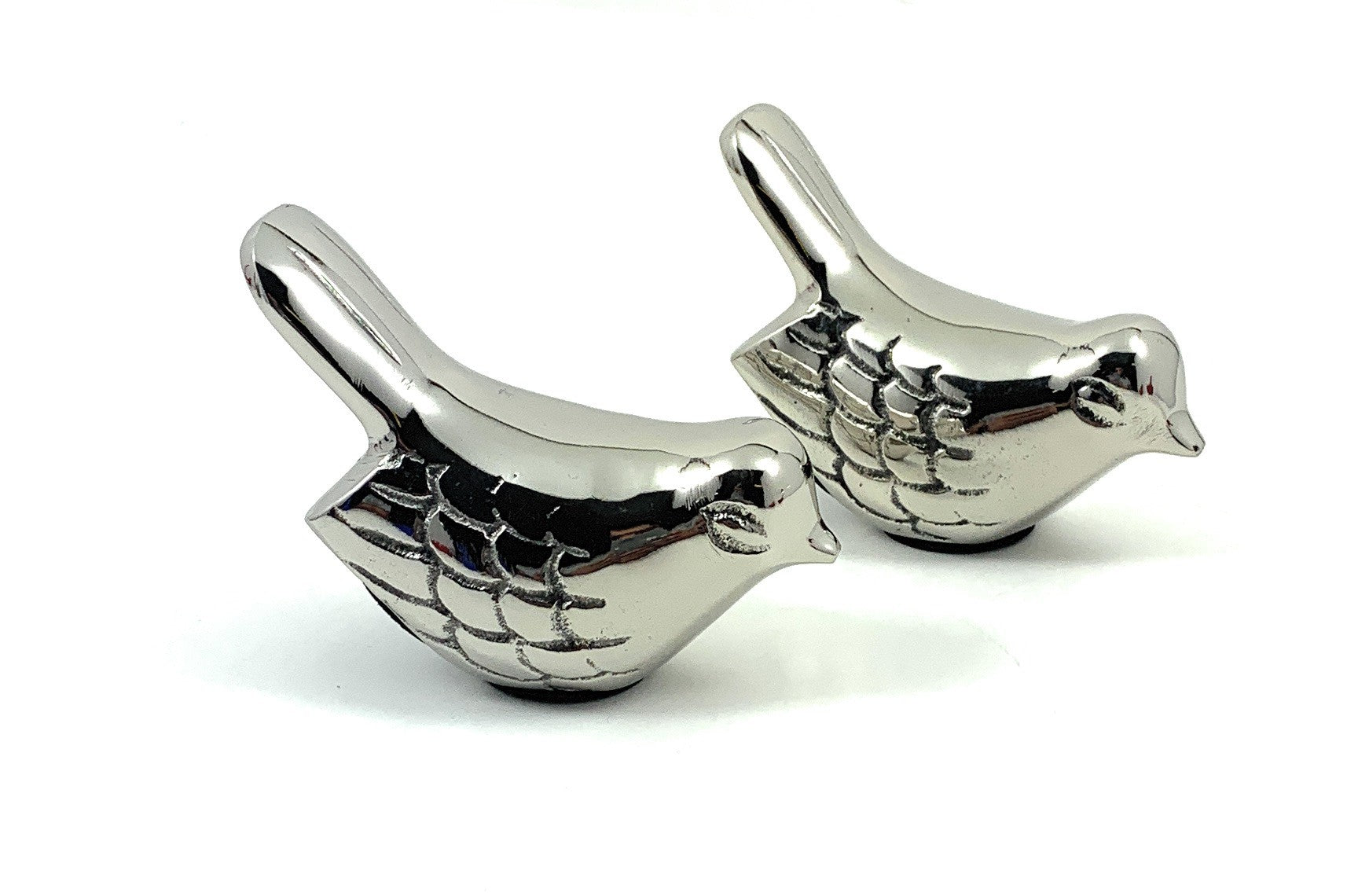 Two silver bird figurines from Vibhsa, positioned on a wooden surface.