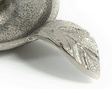 Close-up of a silver candlestick holder dish with a textured leaf-shaped handle featuring detailed vein patterns.