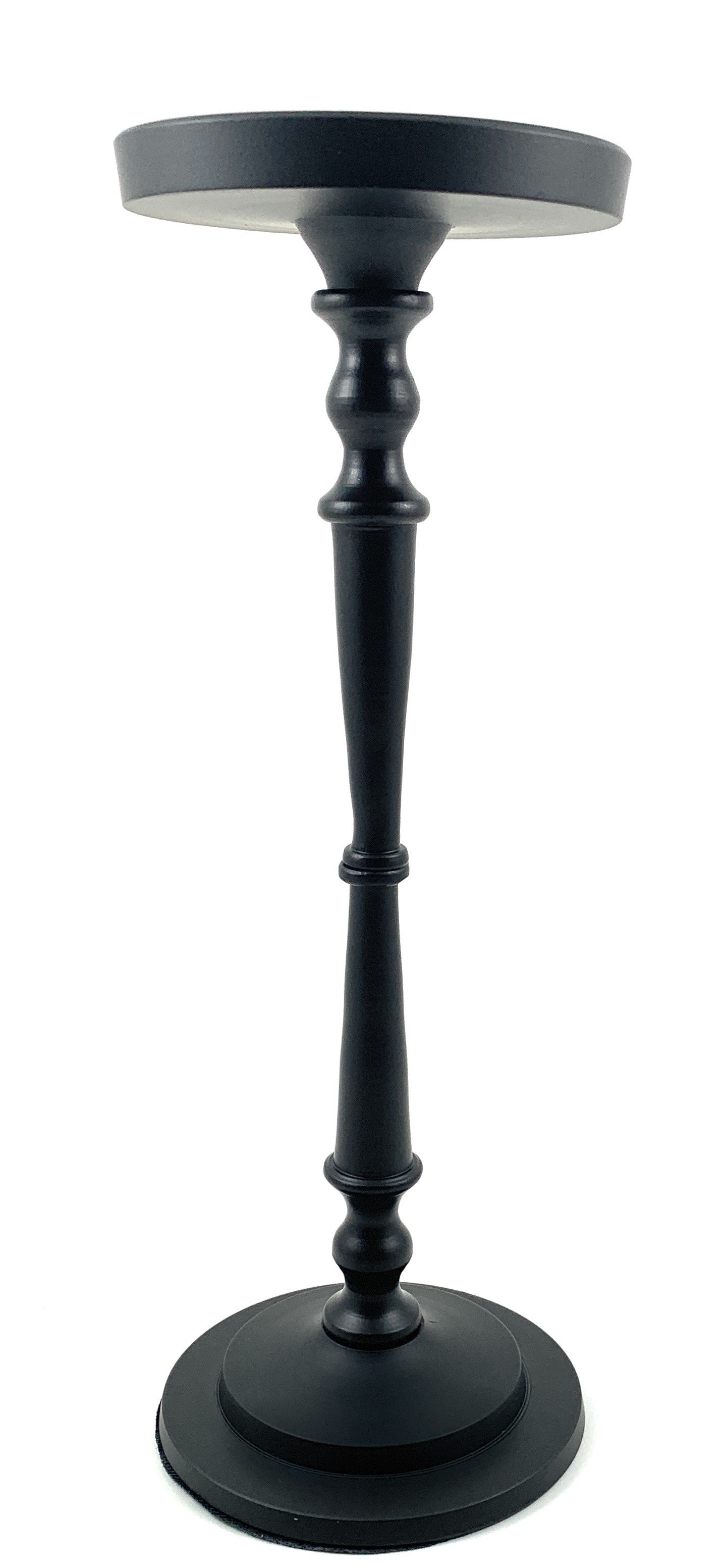 Matte black pillar candle holder by Vibhsa holding a beige candle on a warm wooden surface.