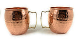 Two hammered copper Moscow Mule mugs with brass-toned handles, shown side by side on a white background.