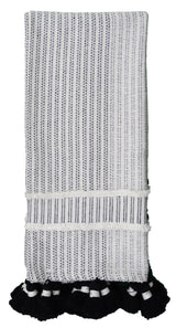 Handwoven textured throw in black and off-white featuring vertical stripe patterns and thick black and white tassels on one end, displayed folded.