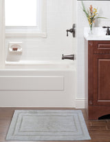 Ivory Color Plain Bath Rug by CHICOS HOME, showing simple border on bathroom floor