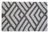 Rectangular bath rug with textured geometric pattern featuring intersecting dark grey and ivory lines in a labyrinth design