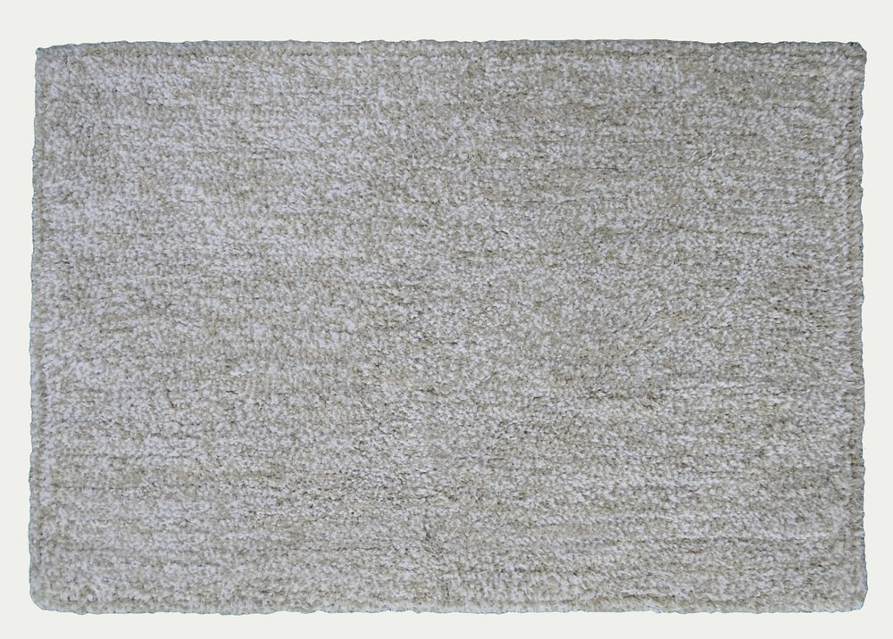 Ivory and white geometric patterned bath rug by CHICOS HOME on bathroom floor