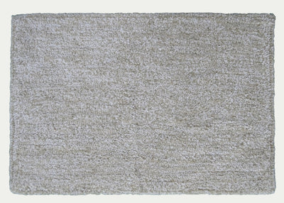 Ivory and white geometric patterned bath rug by CHICOS HOME on bathroom floor