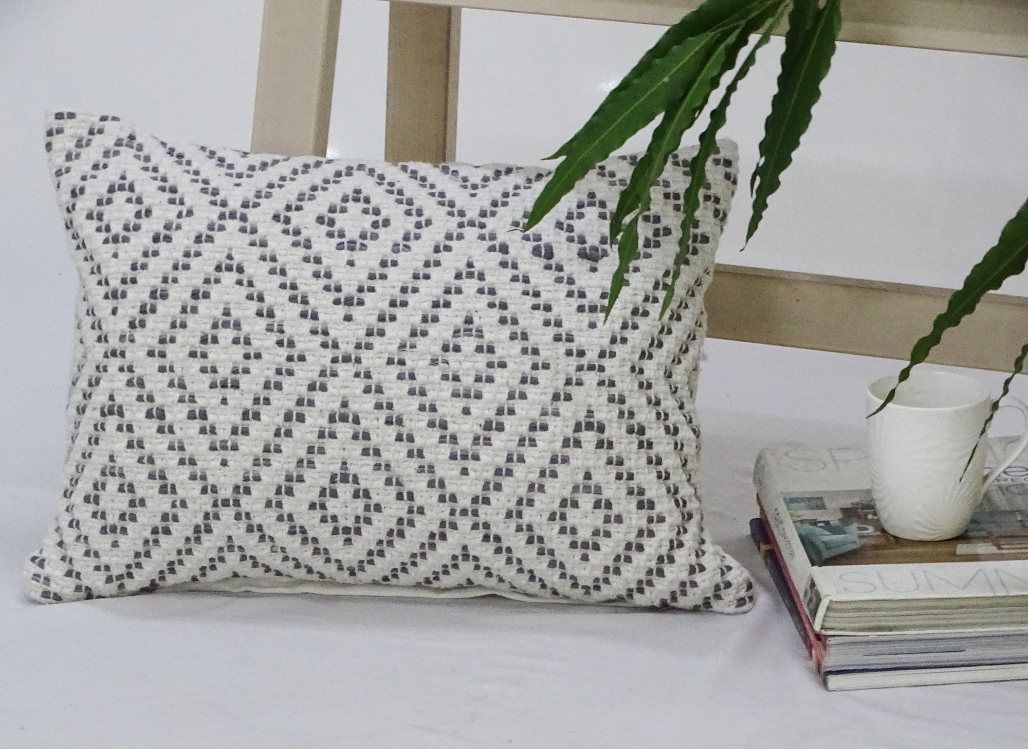 Decorative cotton throw pillow with diamond pattern texture resting on a chair