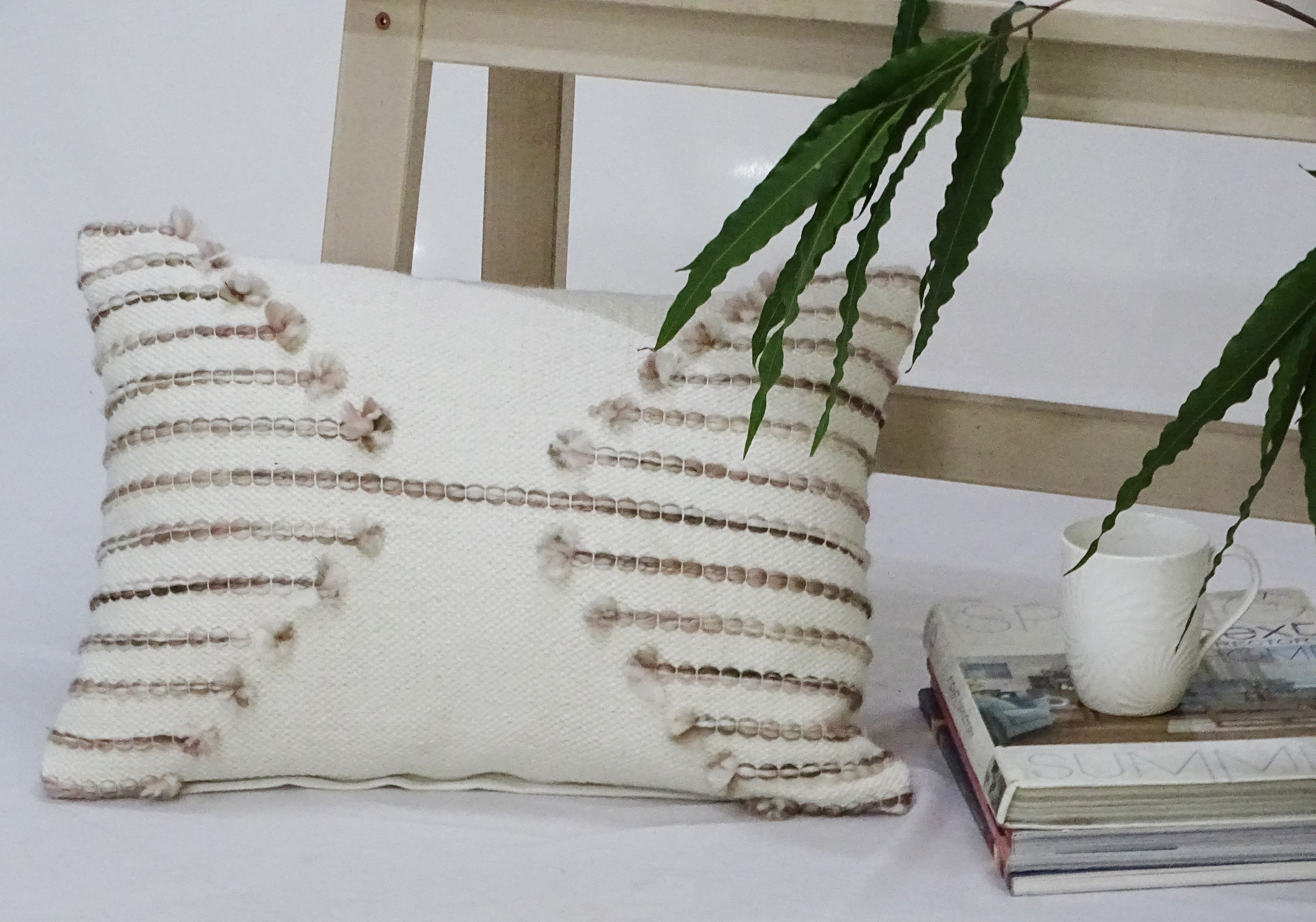 Pink embroidered throw pillow with light pink embroidery on front and solid color back