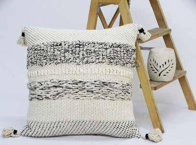 Black and beige striped 22x22 inch throw pillow with corner tassels on a neutral couch