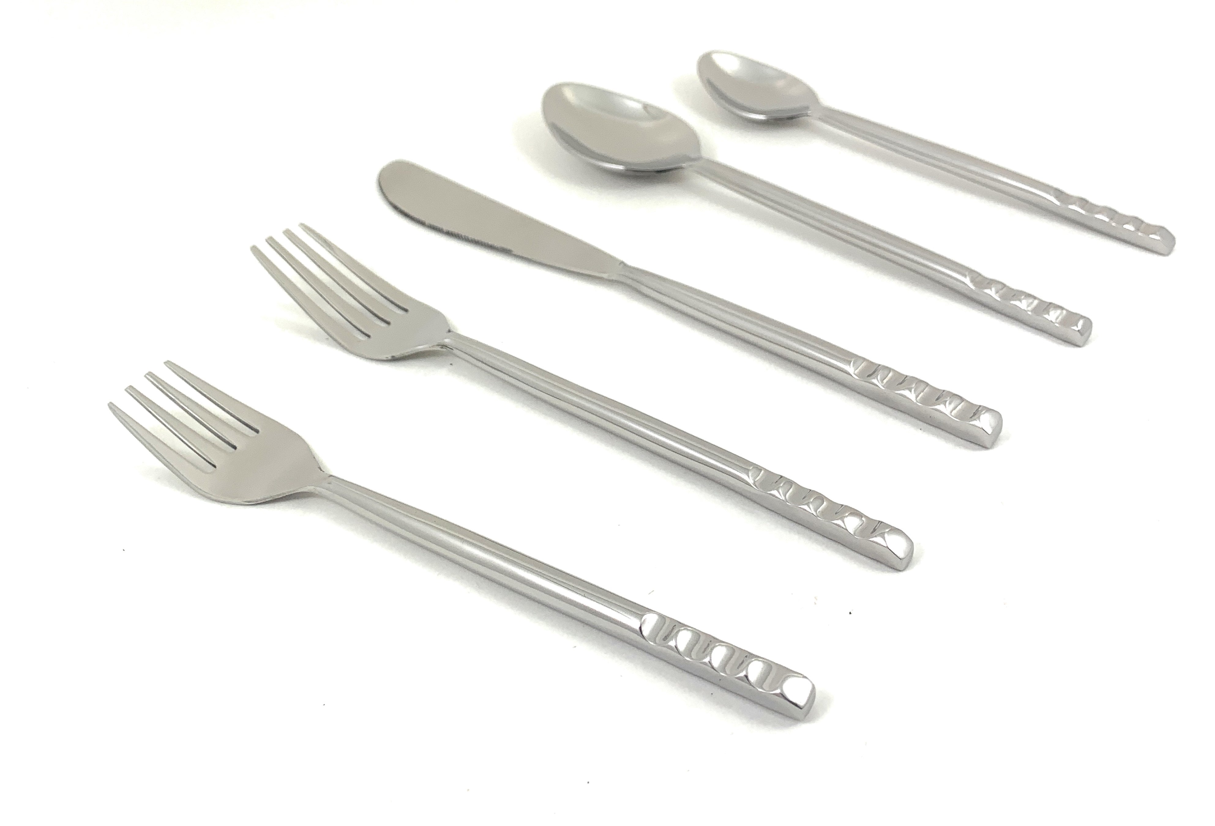 Glossy silver stainless steel flatware set laid out on a blue surface including fork, knife, tablespoons