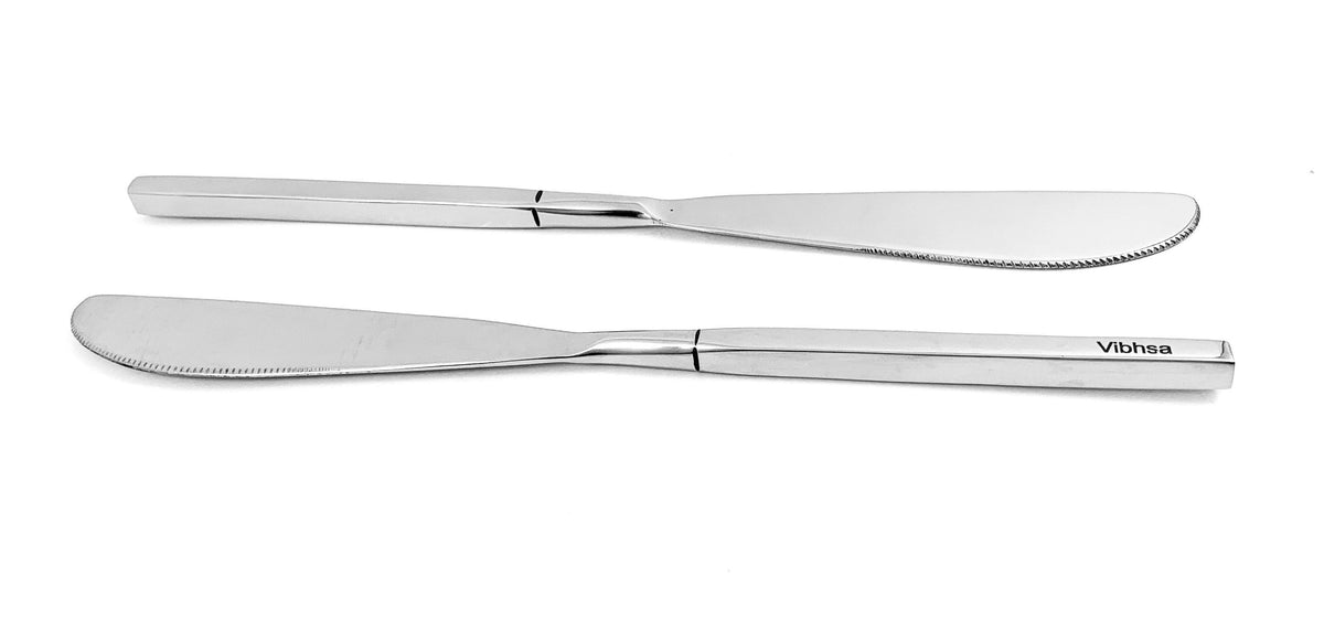 Two stainless steel dinner knives with smooth, slightly curved blades and square-edged handles, one shown flat and the other reversed, both marked with the Vibhsa logo.